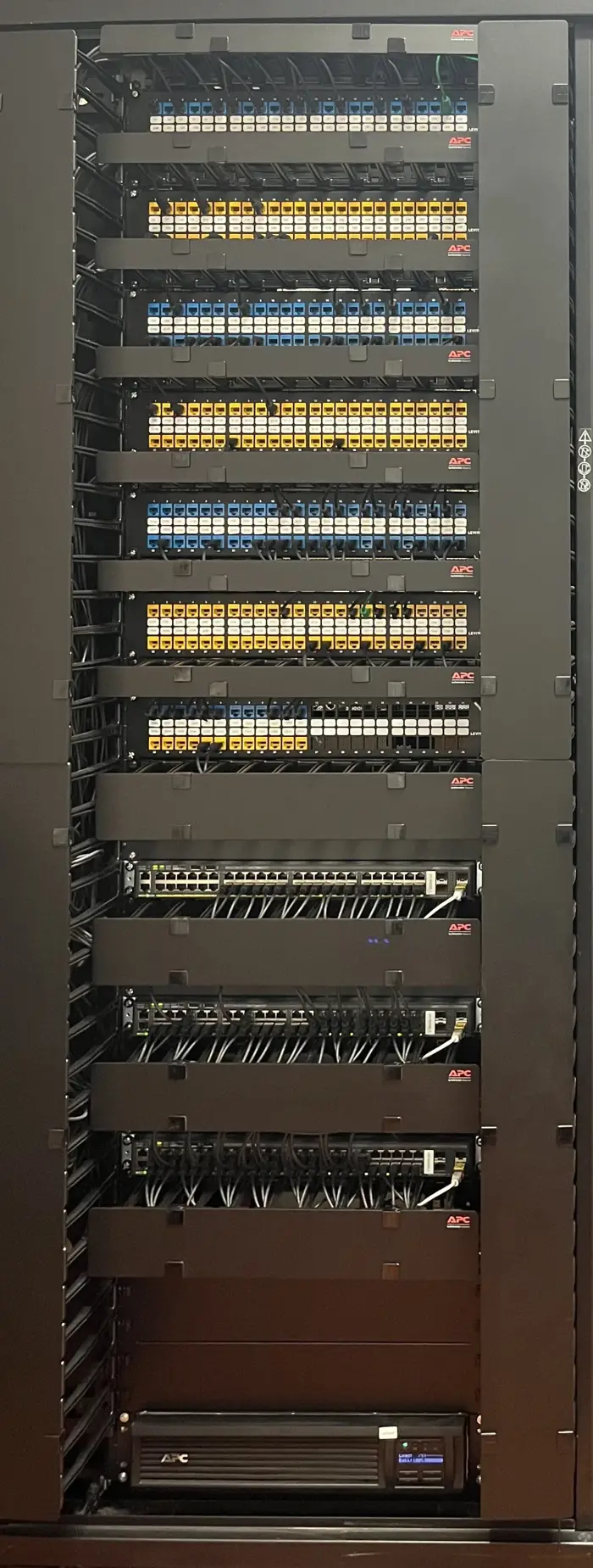 A floor-to-ceiling equipment rack with neatly dressed patch panels.